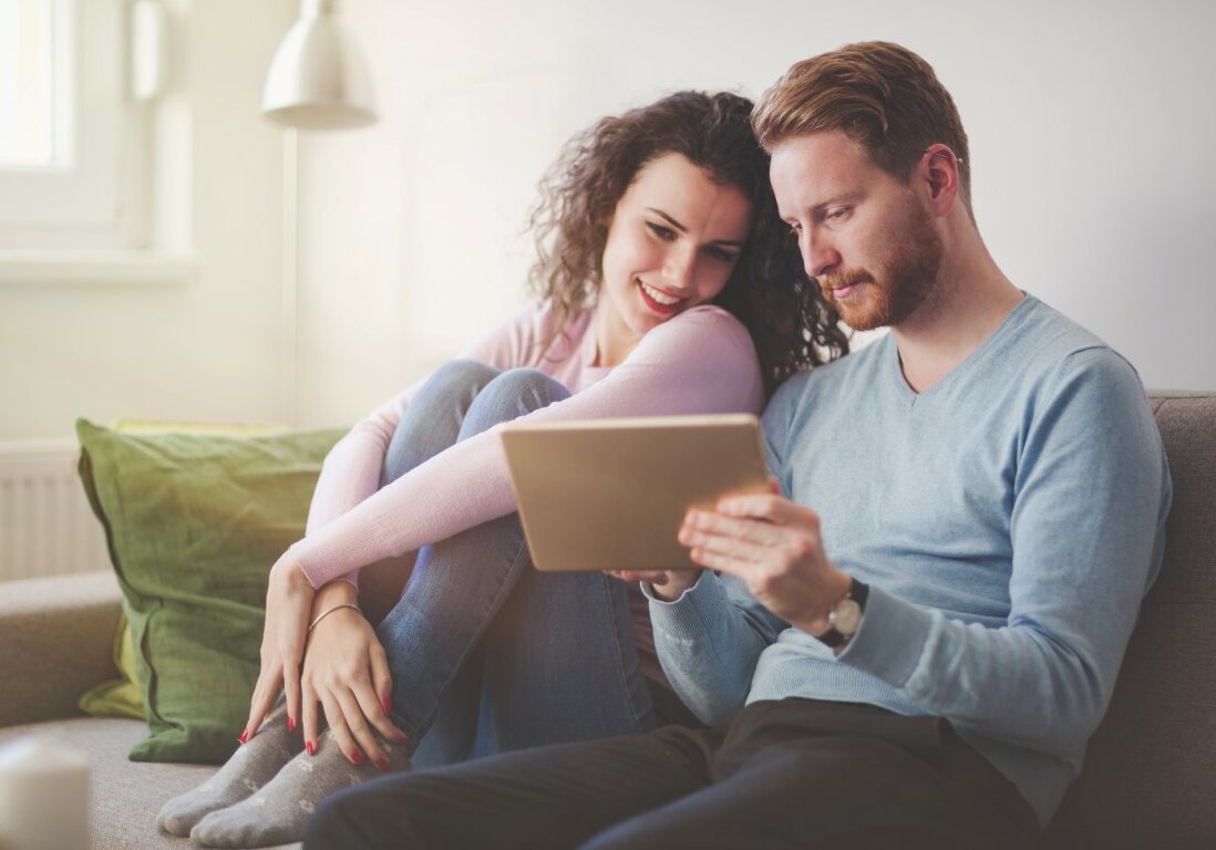 Happy couple in love surfing on tablet at home